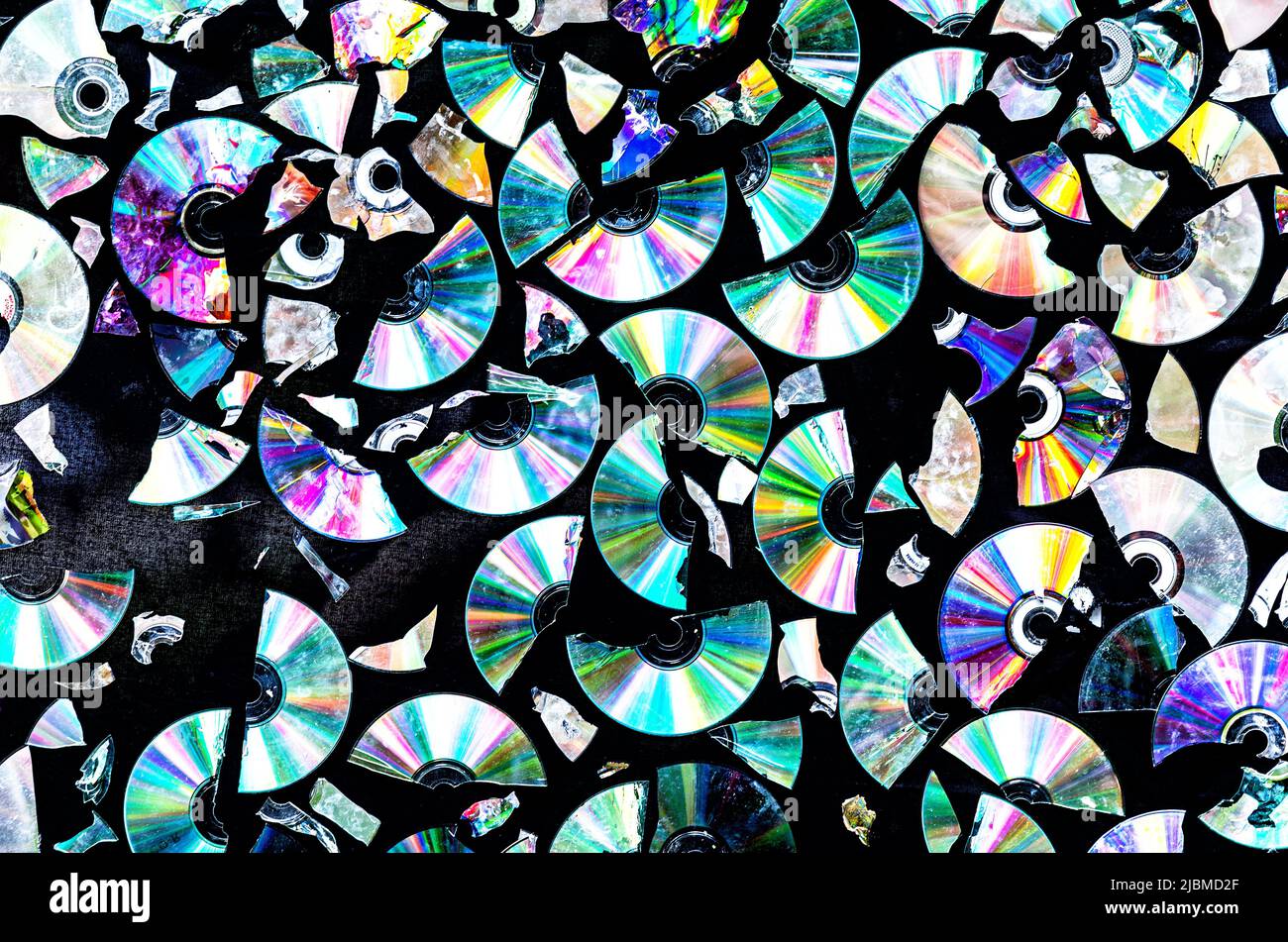 Creative background made of broken CD and DVD data discs Stock Photo