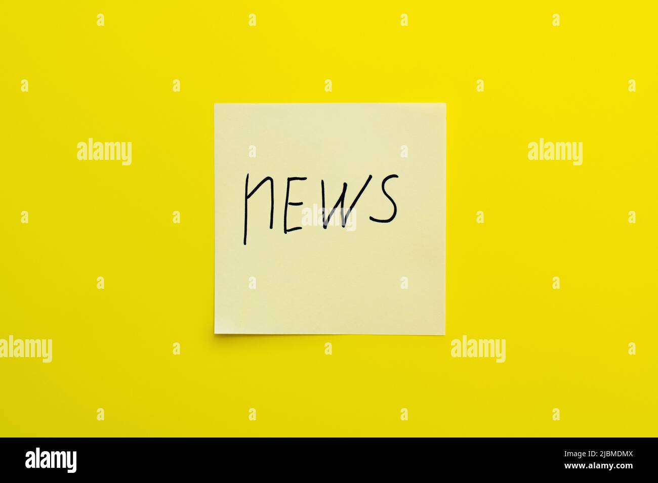 top view of sticky note with handwritten news lettering on bright ...