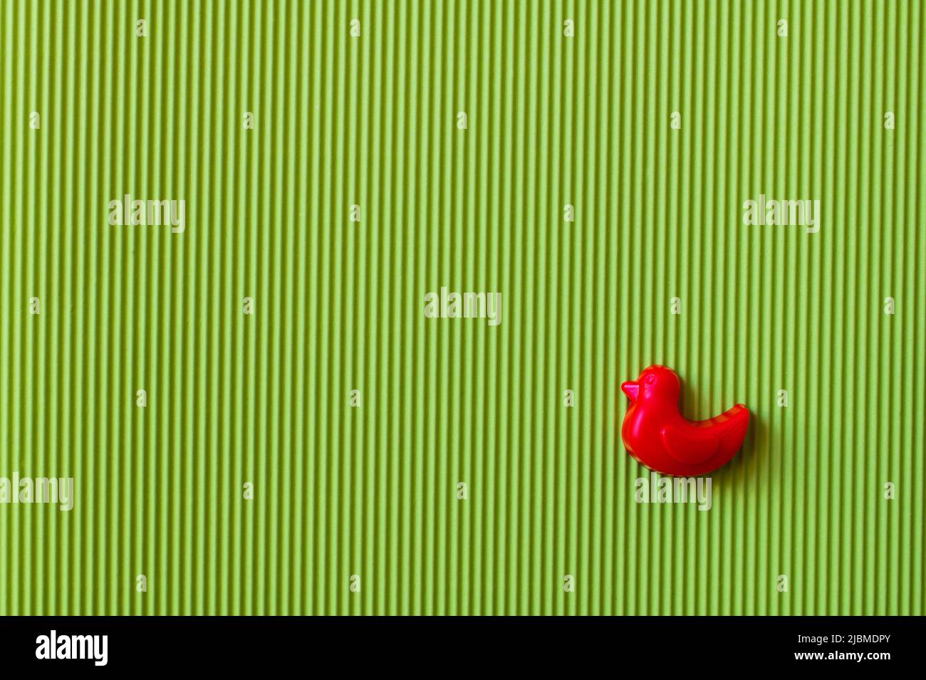 top view of red mold in shape of duck on green textured background Stock Photo