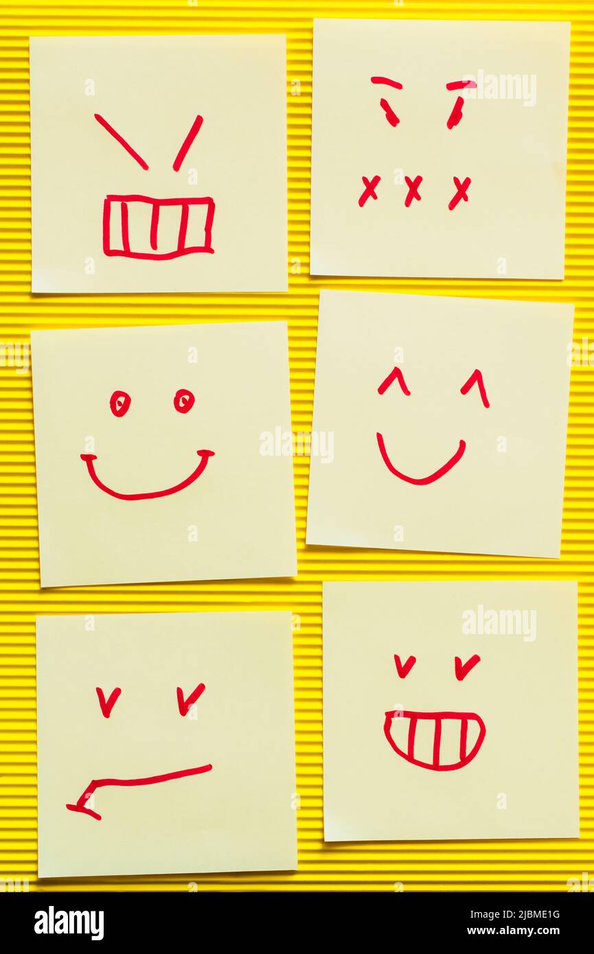 top view of cards with cheerful and angry emoji on yellow textured background Stock Photo