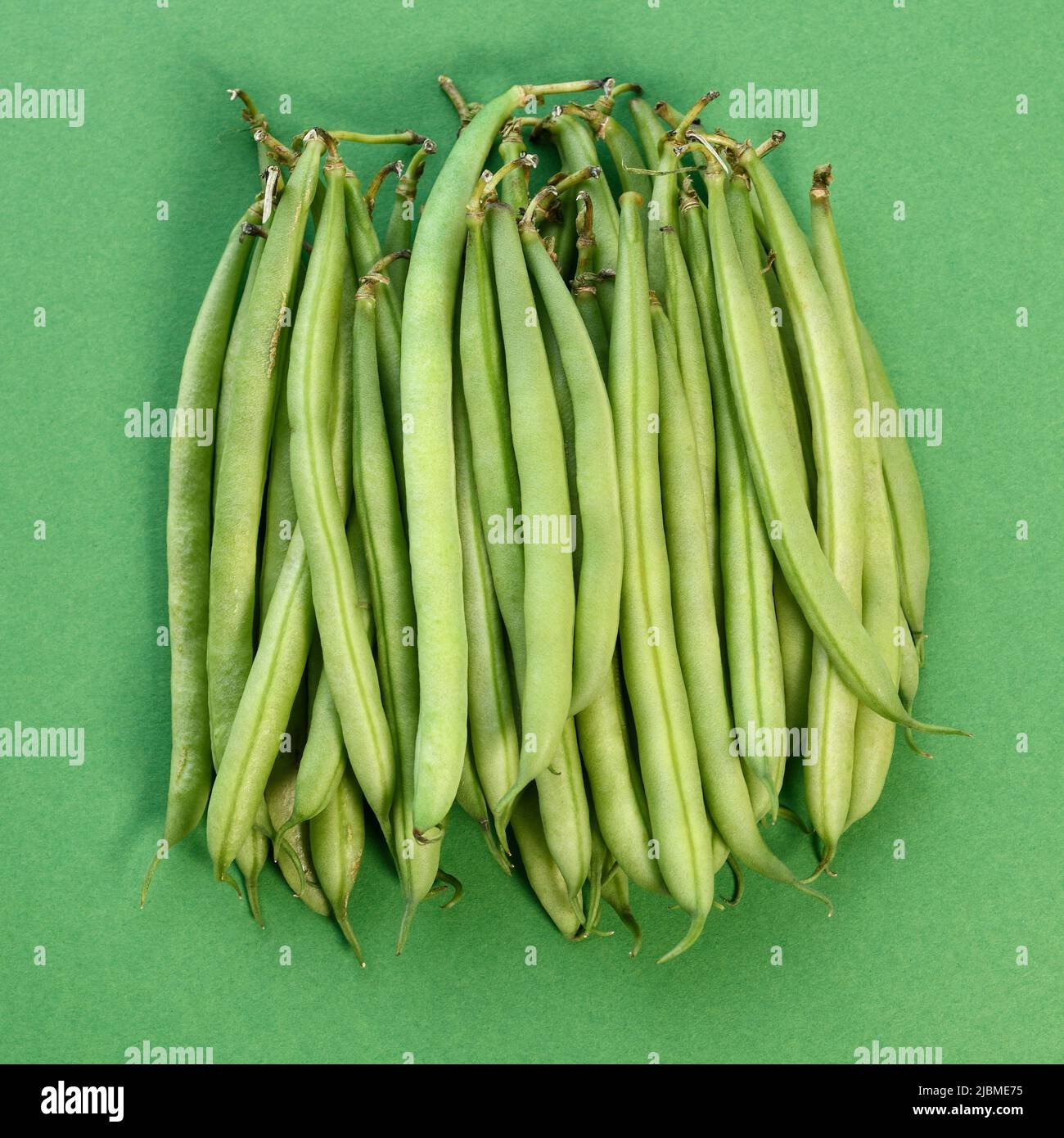 A pile of green french beans on a green background Stock Photo