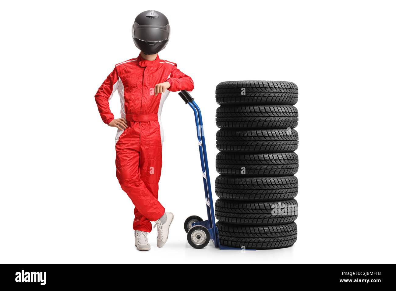 Full length portrait of a racer with a helmet and suit leaning on a hand truck with tires isolated on white background Stock Photo