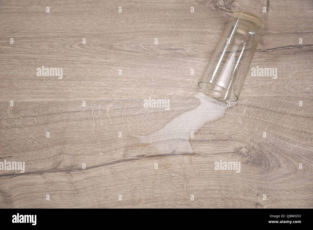 Glass of water fell on laminate, water spilled on floor Stock Photo Alamy
