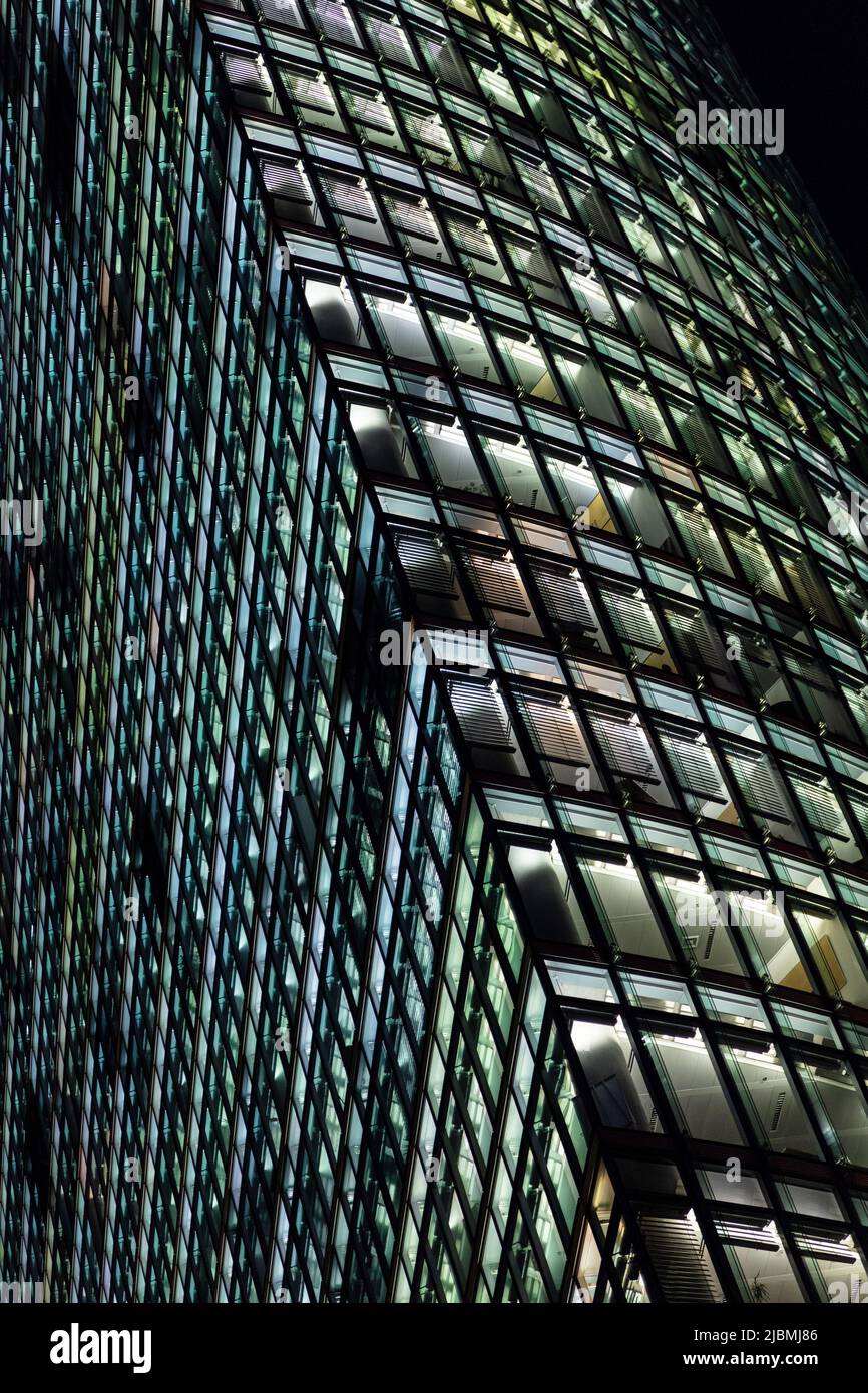 Modern city office building, skyscraper ay night with the lights on in windows Stock Photo
