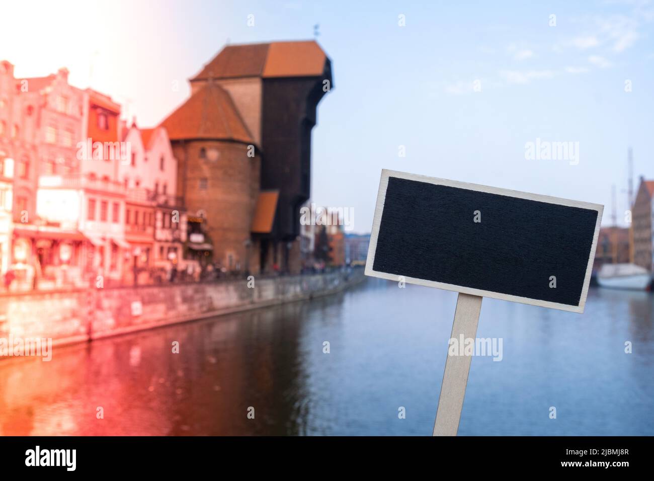 Empty mockup template Blackboard label against Gdansk beautiful old town over Motlawa river. The Zuraw Crane and colorful gothic facades of the old to Stock Photo