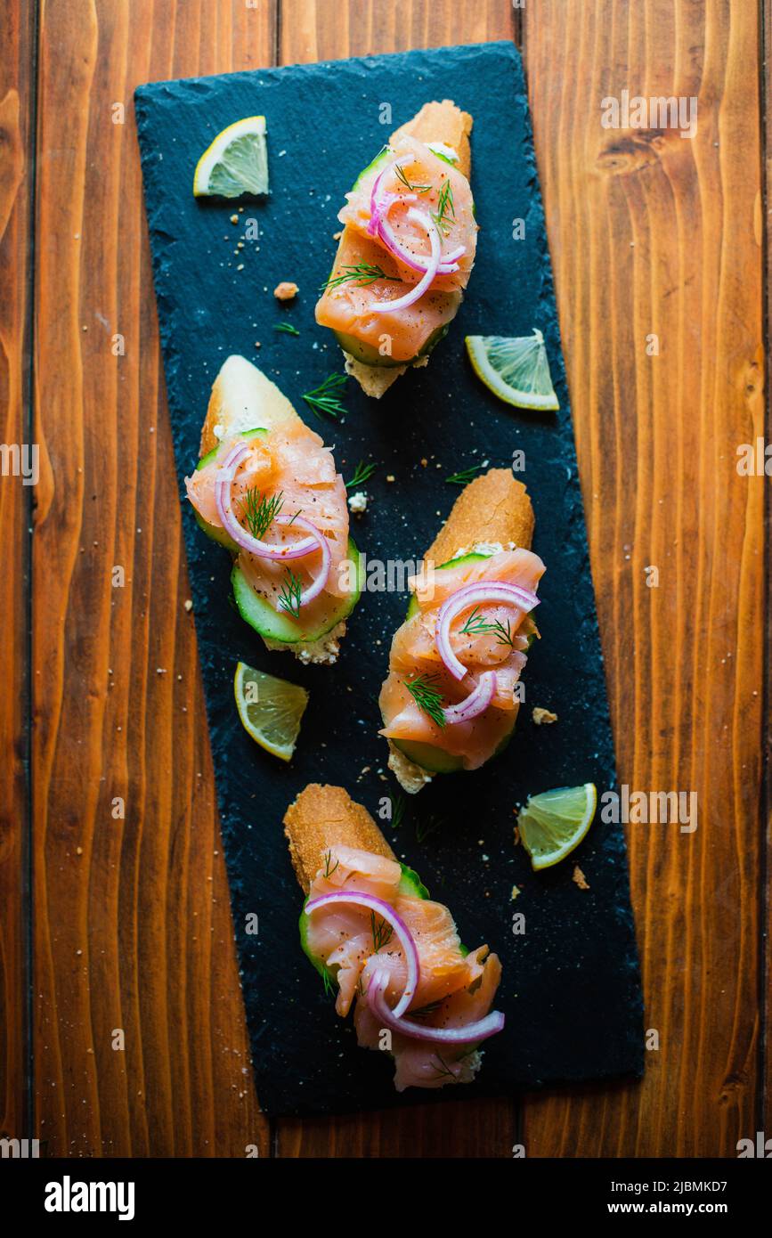 Smoked salmon on a baguette with cream cheese, cucumber, pickled red