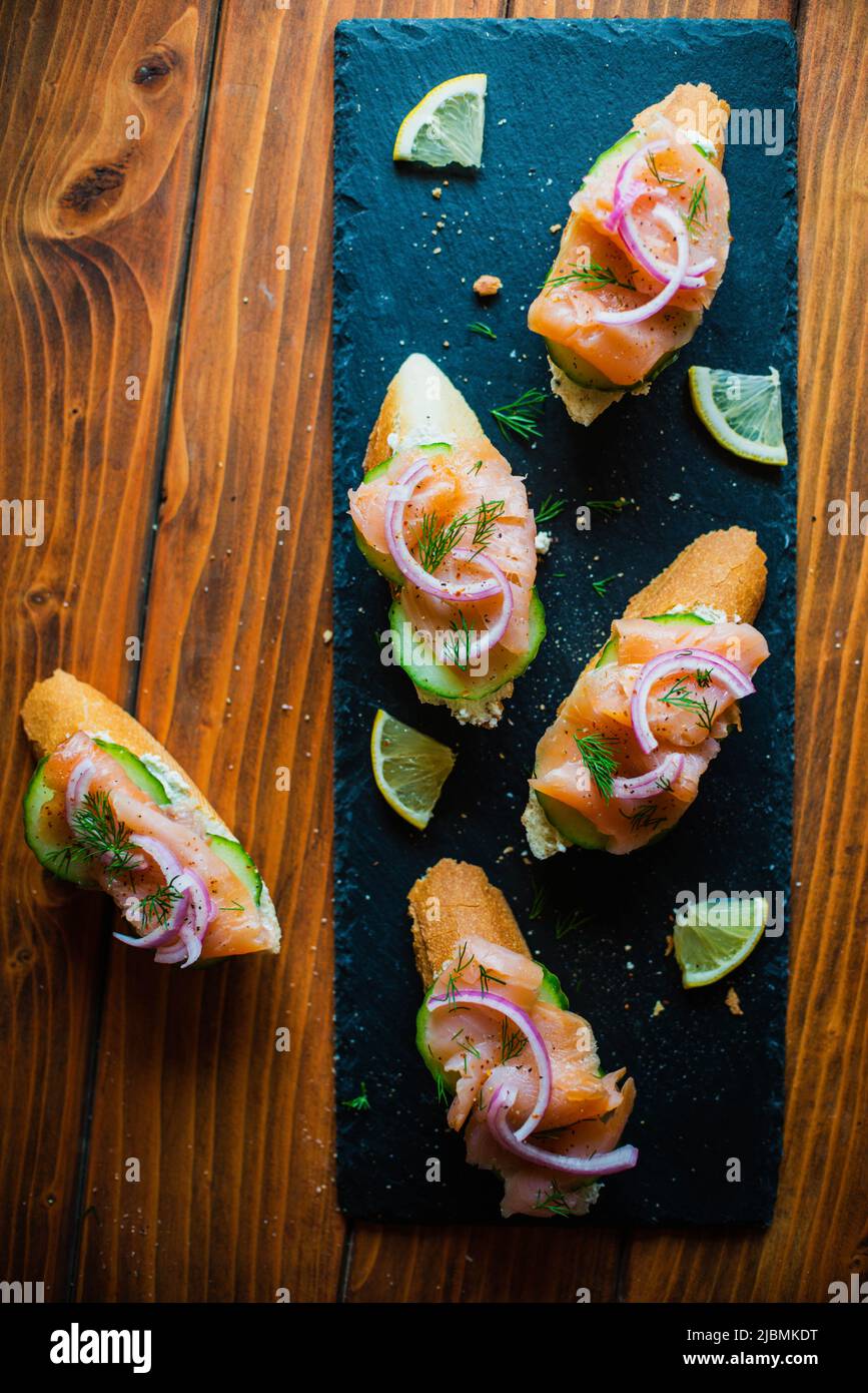 Smoked salmon on a baguette with cream cheese, cucumber, pickled red