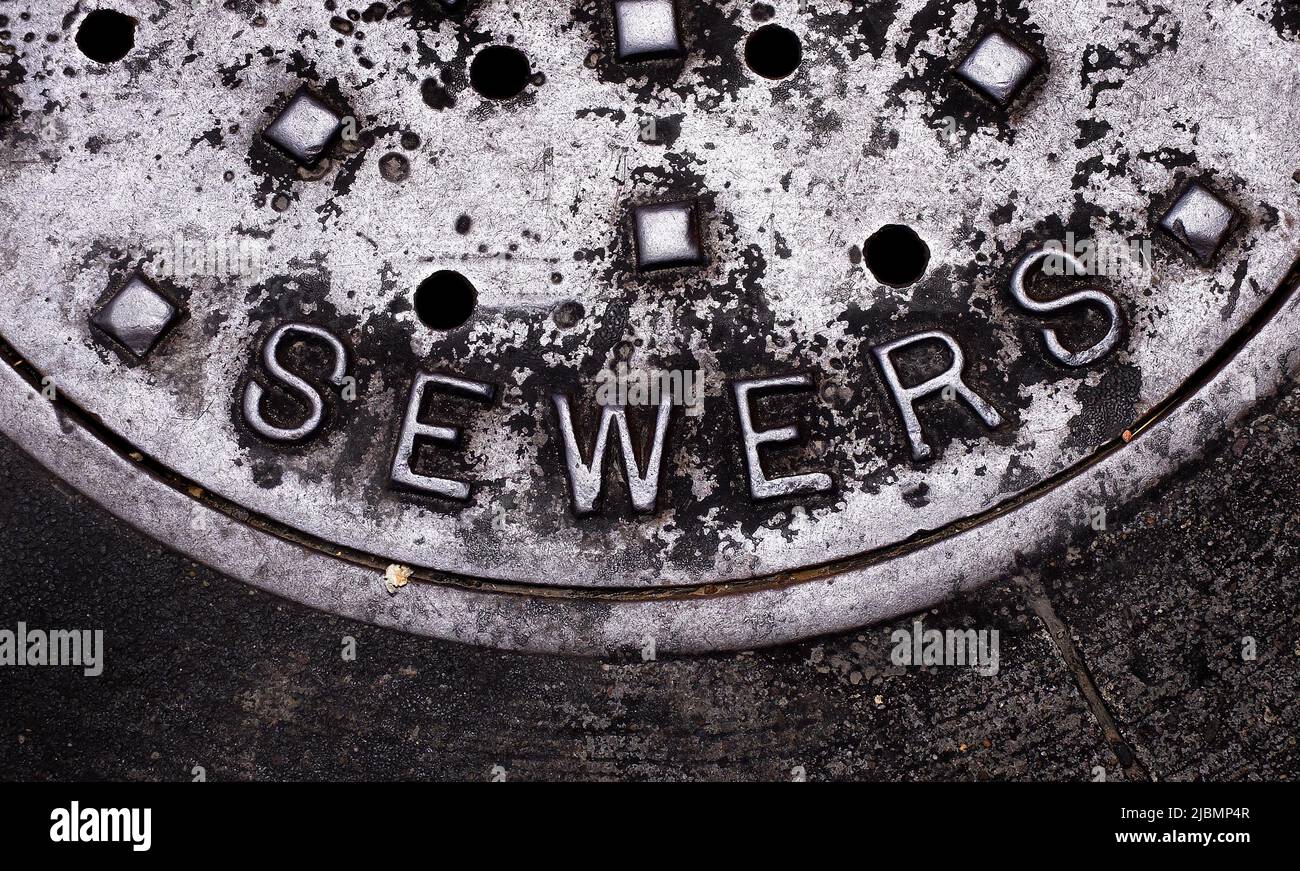 Sewer man hole cover of an iron lid for access to sewer lines Stock