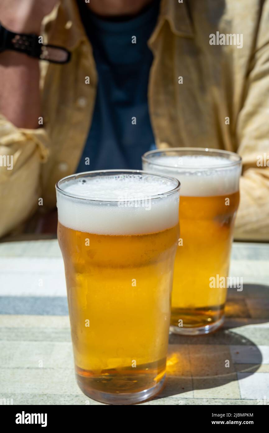Men with two glasses of fresh cold lager beer in French outdoor cafe in