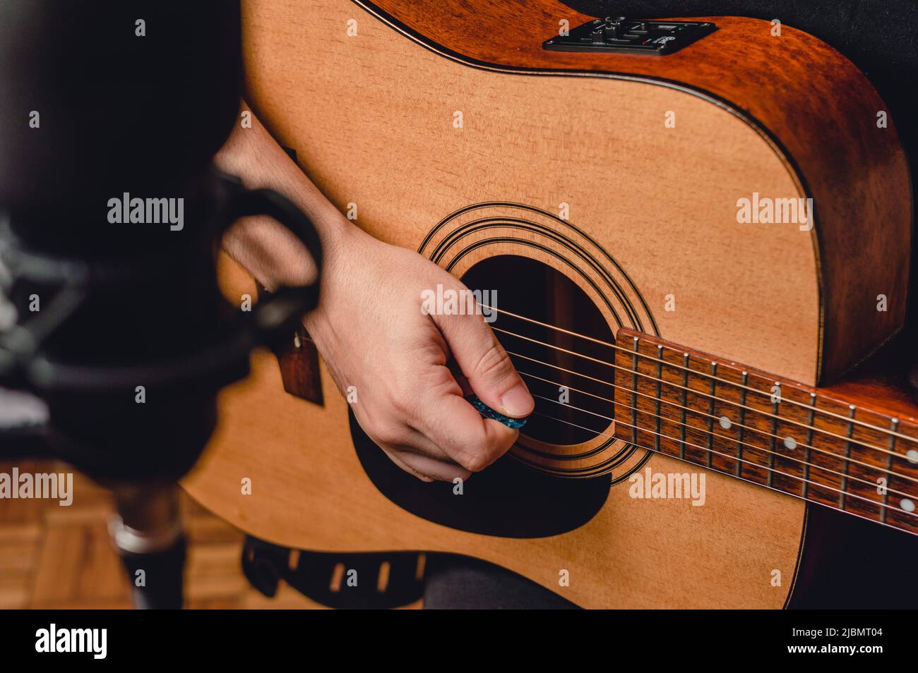front view unrecognizable male caucasian guitarist, in studio recording