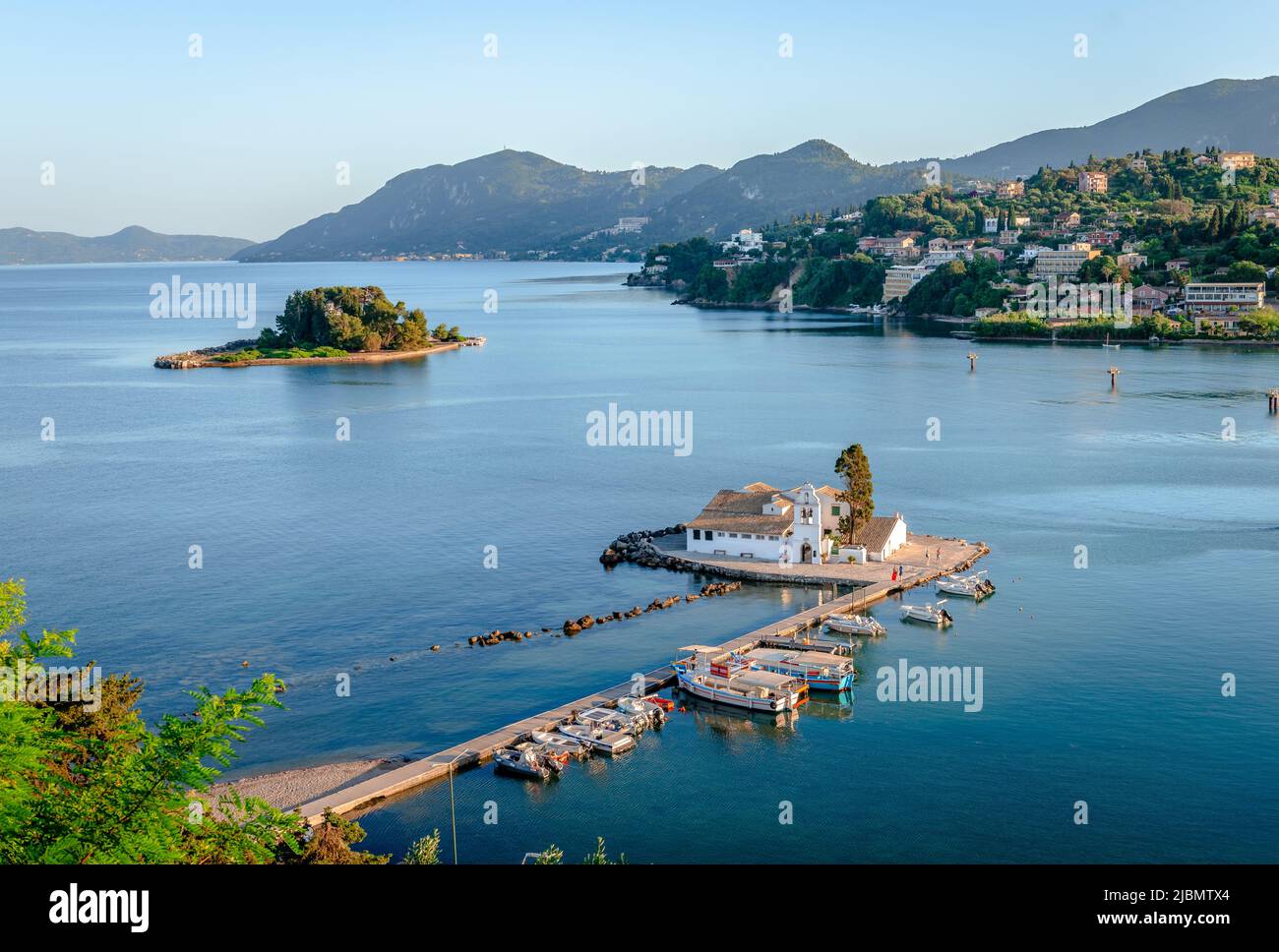 The Vlacherna Monastery and the Mouse Island with Perama in the background in the evening. Corfu Island, Greece Stock Photo
