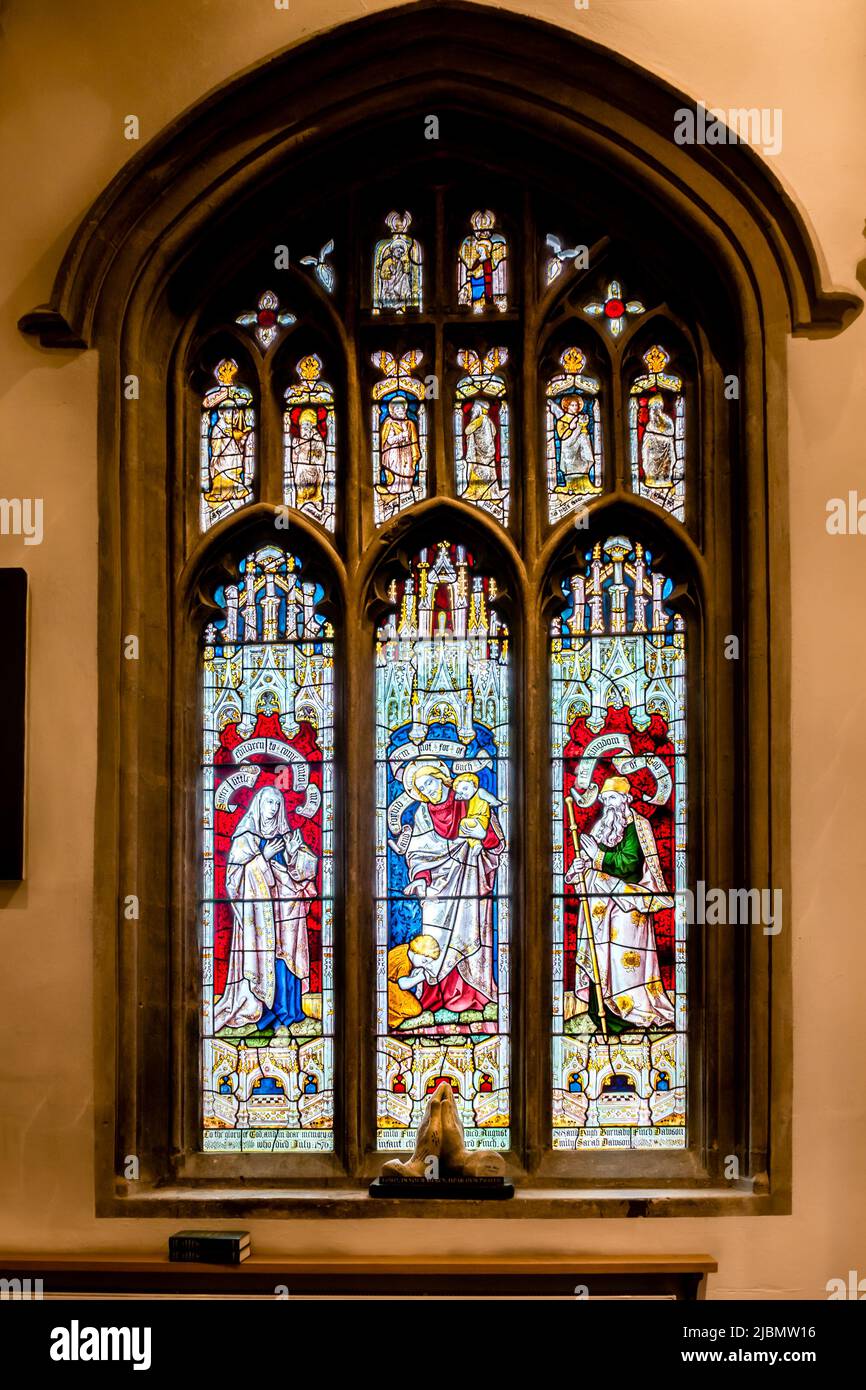 Beautiful bright stained glass window in pointed arch, part medieval part Victorian, in Launde Abbey chapel Stock Photo
