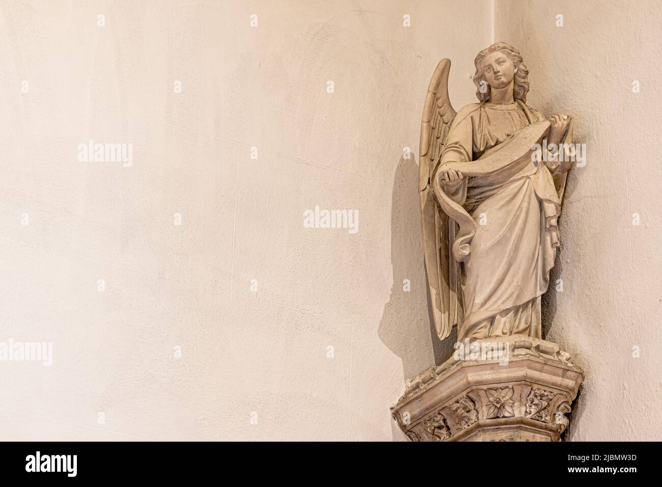 Beautiful ornate carved statue of an angel figure on a church wall with copy space Stock Photo