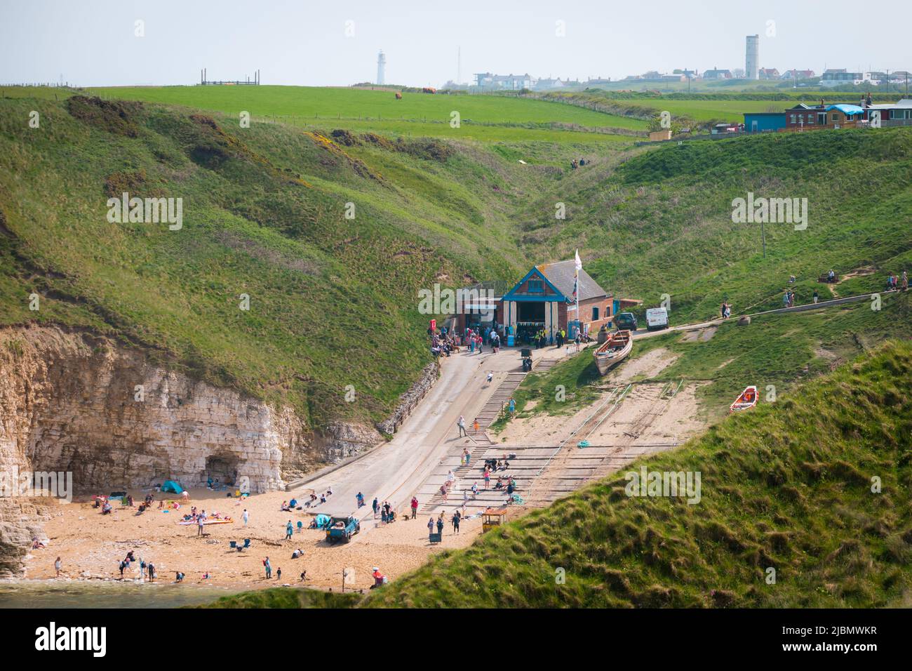 Wide landscape of the slipway, beach and RNLI lifeboat house at Flamborough North Landing on a sunny day Stock Photo