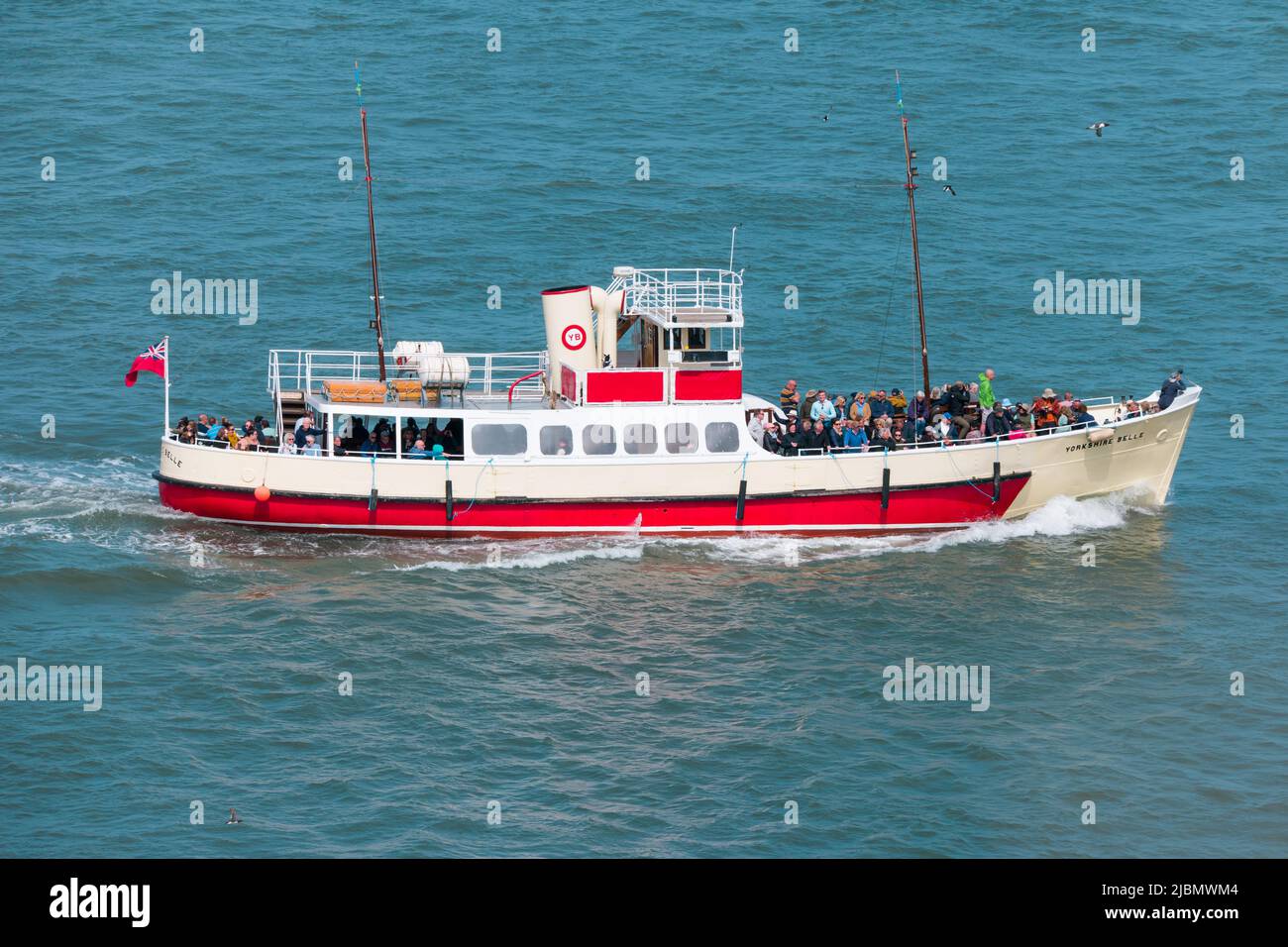 Yorkshire Belle, a pleasure cruiser boat, at sea with tourists in sunshine around Bridlington Stock Photo