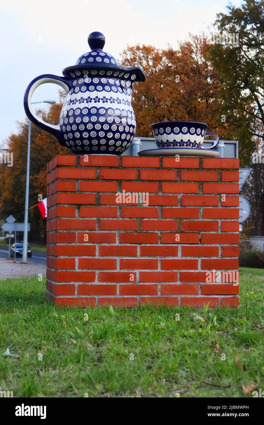 Blue and white pottery teapot and teacup on a saucer on a brick stand in a roundabout in Boleslawiec, Poland. Stock Photo