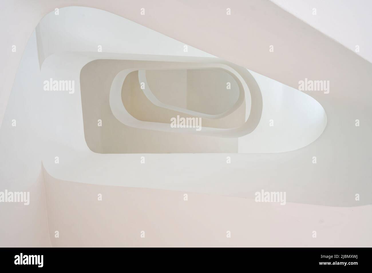 Looking up a modern stone built spiral staircase Stock Photo