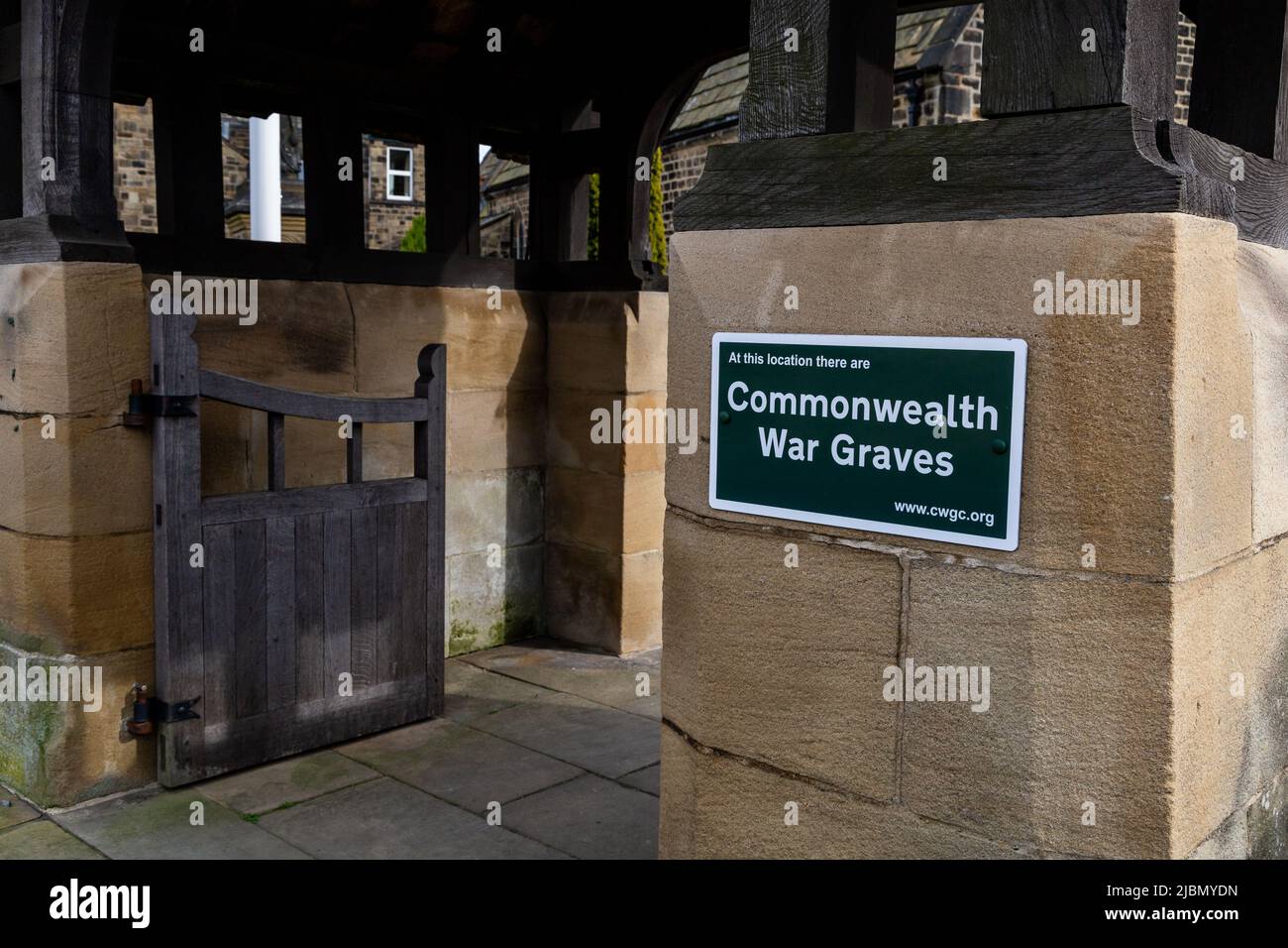 A green and white Commonwealth War Graves sign at the Lychgate of St John's Church of England, Baildon, Yorkshire. War Graves are located here. Stock Photo