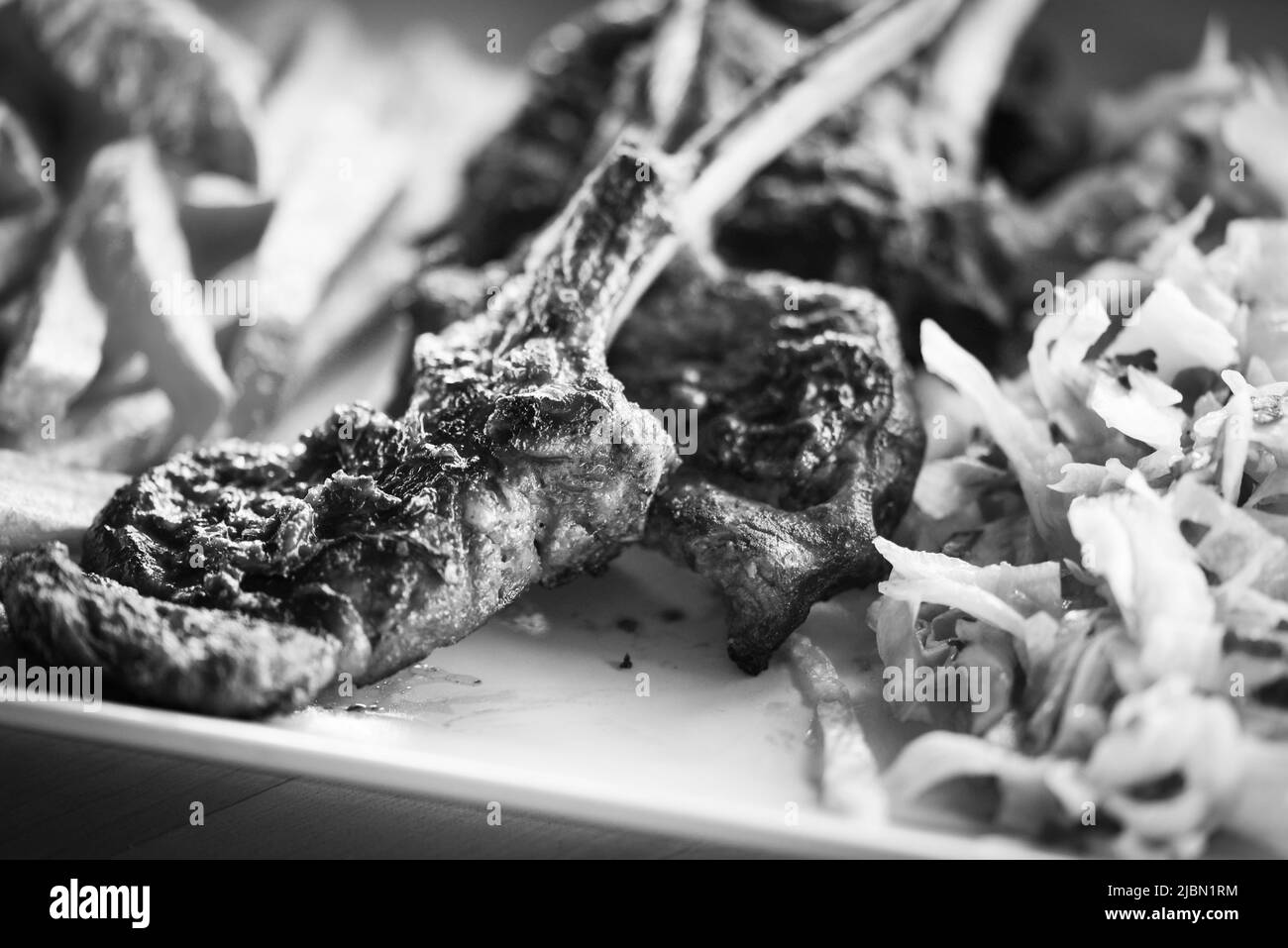 delicious grilled lamb chopsticks with french fries, pesto sauce & mix of lettuces Stock Photo