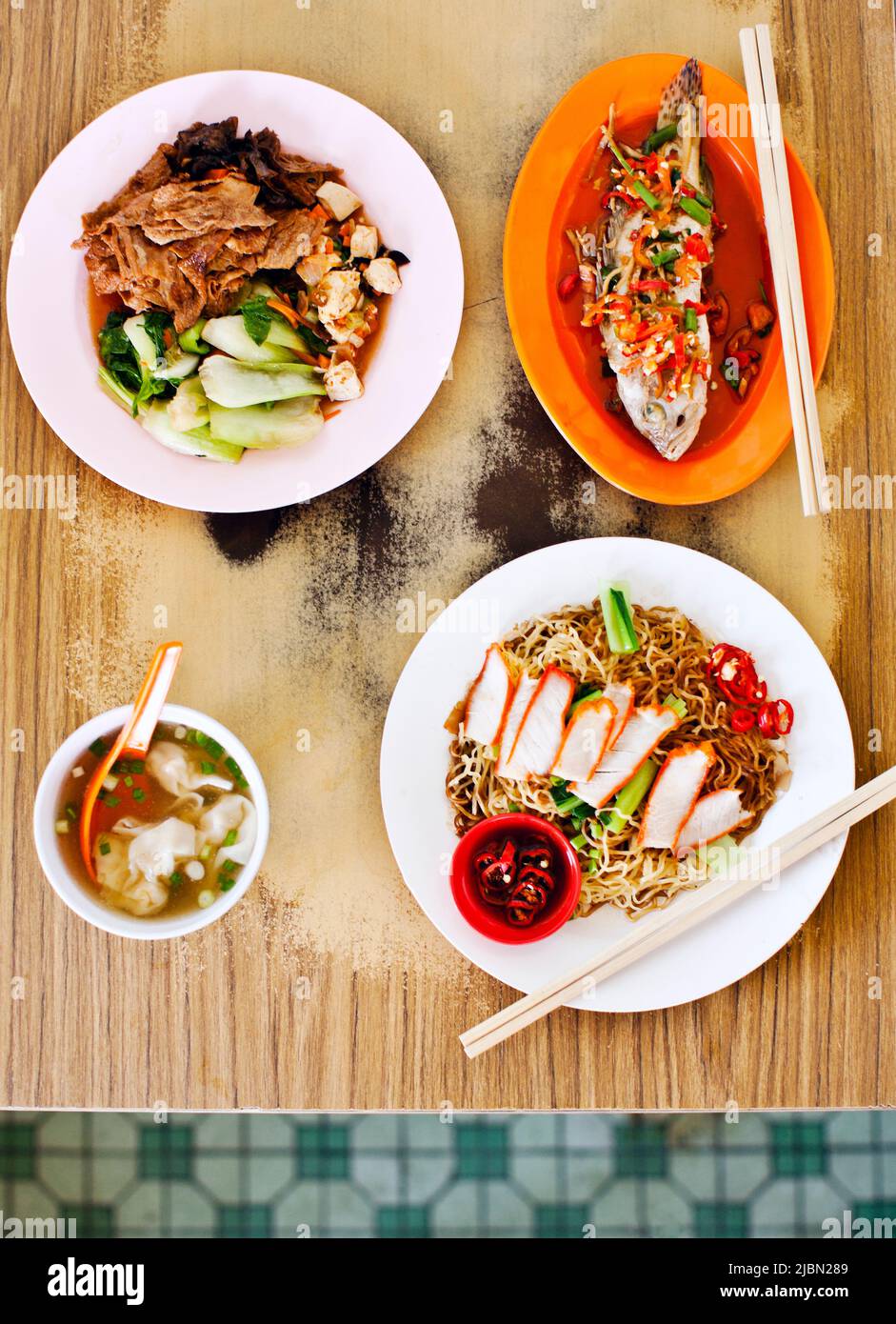 A bowl of won ton mee (noodle soup with roast pork and won tons); a plate of tok tok mee (stir fried noodles with roast pork); won ton soup; fried gro Stock Photo
