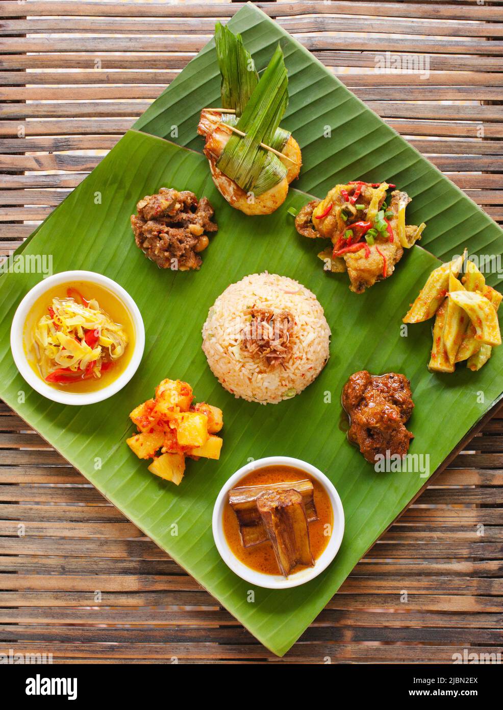 Prawns in Pandan leaf, fish tamarind, beef with peanuts, chicken with lime leaf, pickled lamb curry, ladies finger sambal, pineapple acar, eggplant. Stock Photo