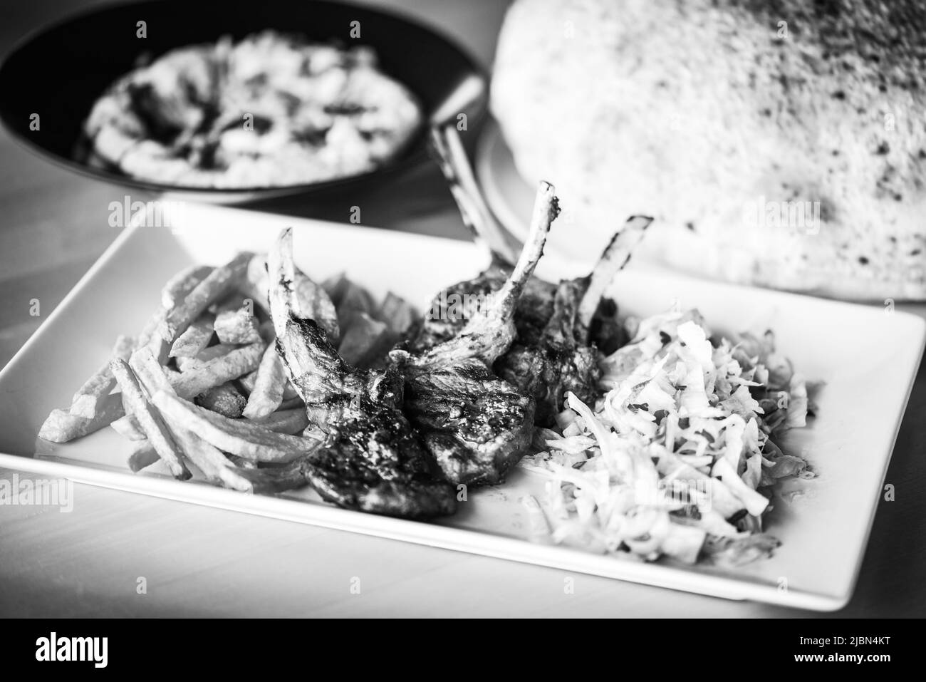 delicious grilled lamb chopsticks with french fries, pesto sauce & mix of lettuces Stock Photo