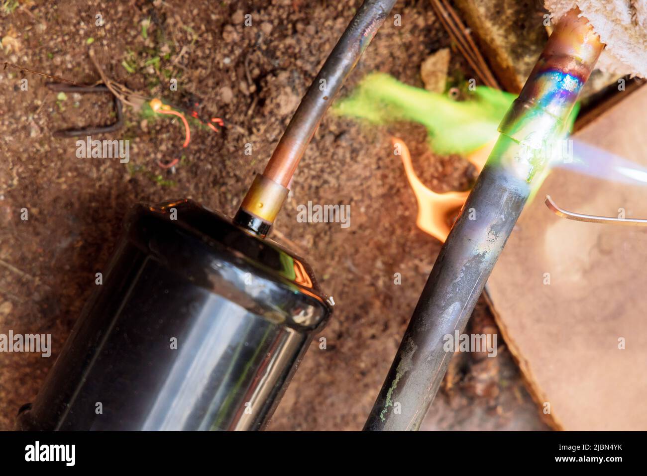 Air conditioning repair with repairman soldering copper pipe gas burner