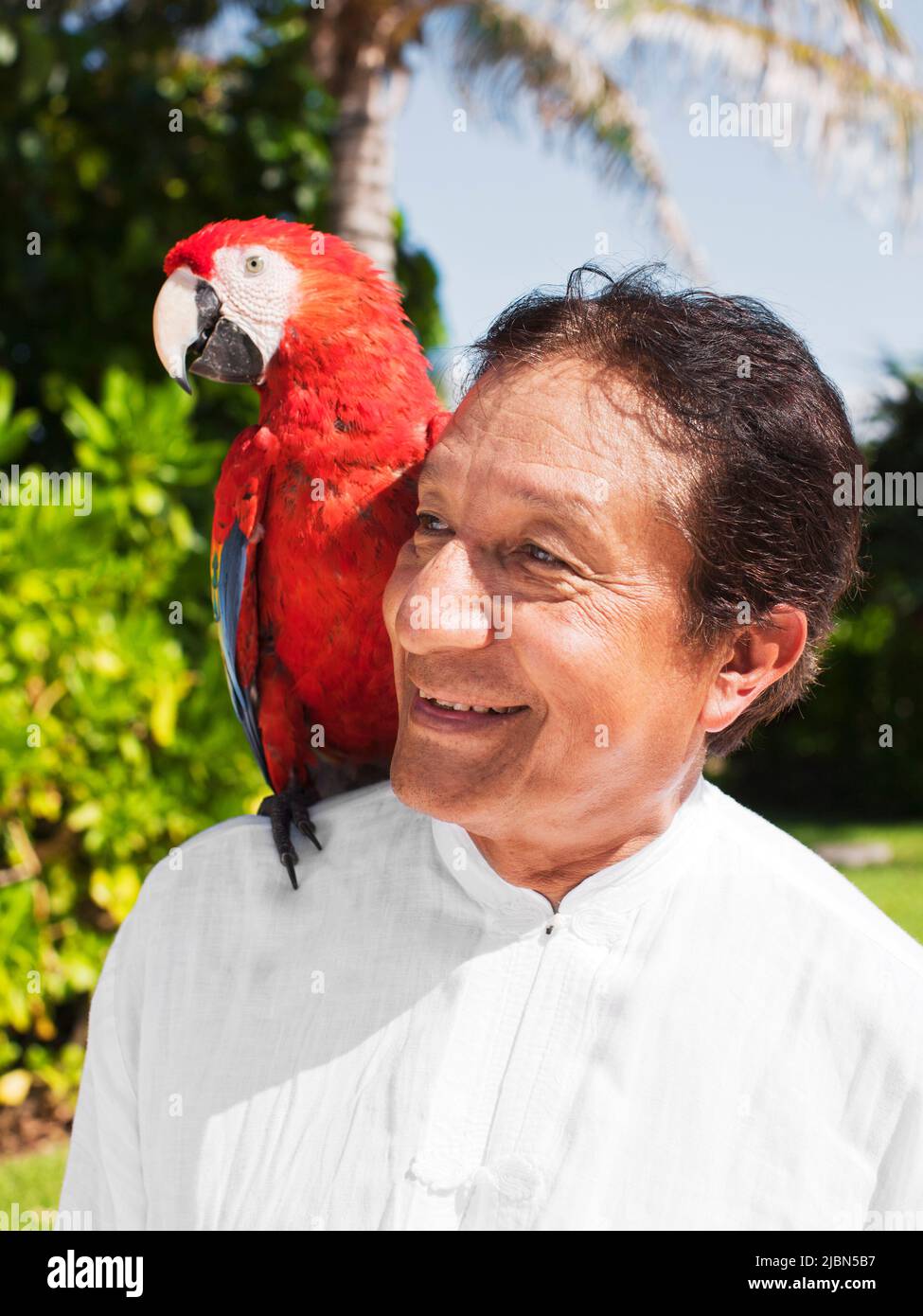 Victor, a tai chi instructor, calls on Billy the parrot, as part of the Macaw Ritual—one of several daily rituals that take place at Live Aqua Resort. Stock Photo