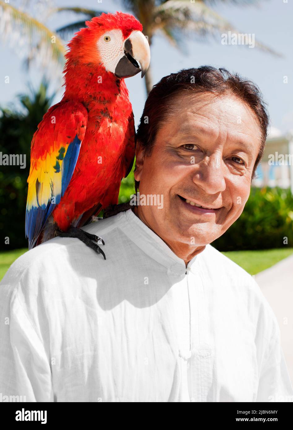 Victor, a tai chi instructor, calls on Billy the parrot, as part of the Macaw Ritual—one of several daily rituals that take place at Live Aqua Resort Stock Photo