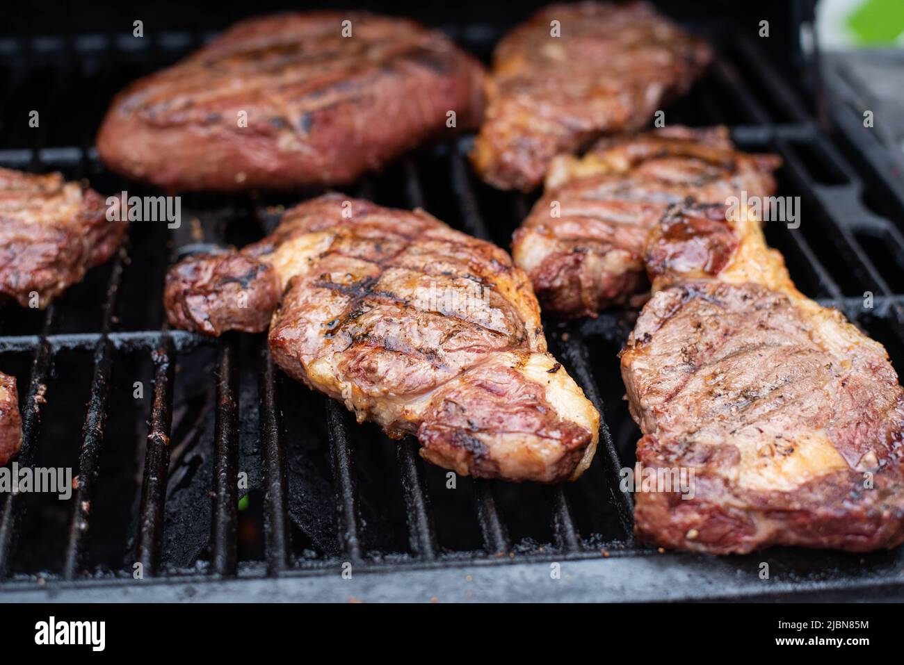 Steaks cooking on a grill. Stock Photo