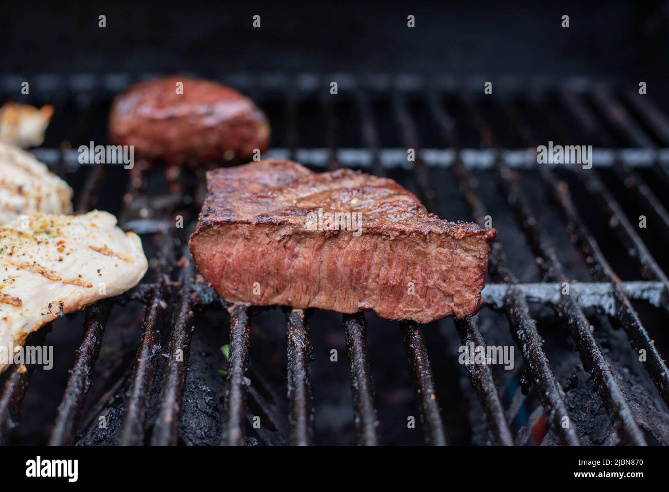 Steaks cooking on a grill. Stock Photo