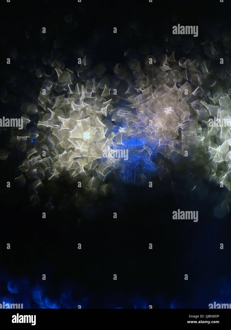 Complex fractals of sparkles in blue and gold colors on a black background. Stock Photo