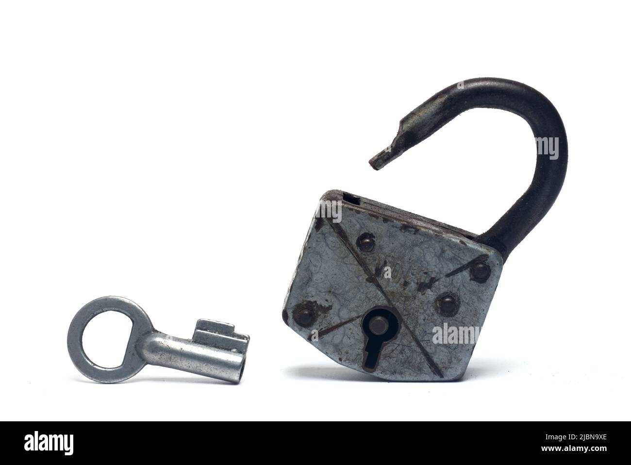 Closeup of silver old shackle U-lock on white background with silver key standing next to it Stock Photo