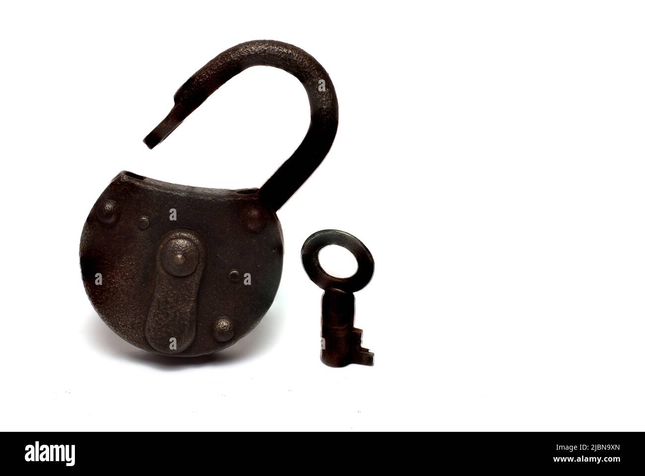 Close up of rusty old shackle lock with open shackle and key next to it on white background Stock Photo