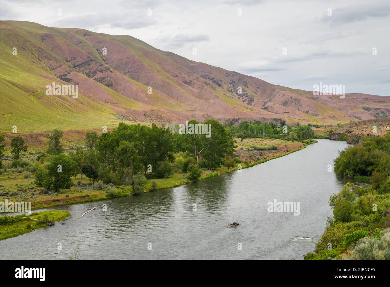 The Yakima River quietly passes rolling hills as it enters the Yakina canyon in Central Washington State Stock Photo