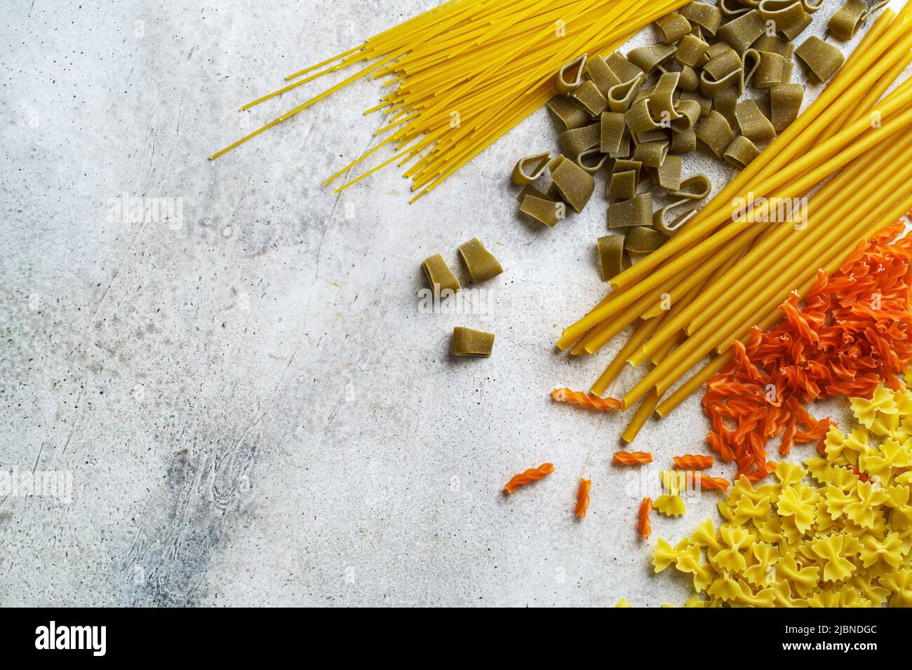 Various colorful pasta backgrounds with copy space. Orange, green and yellow pasta Stock Photo