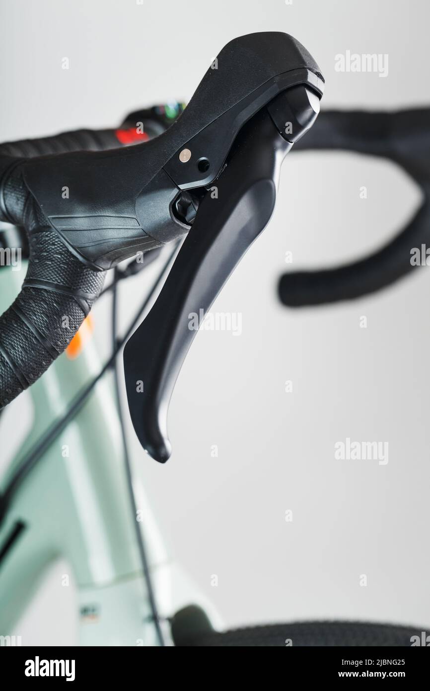 Highway bicycle handlebar in black winding and with brake gearshift knobs on a gray background. Stock Photo