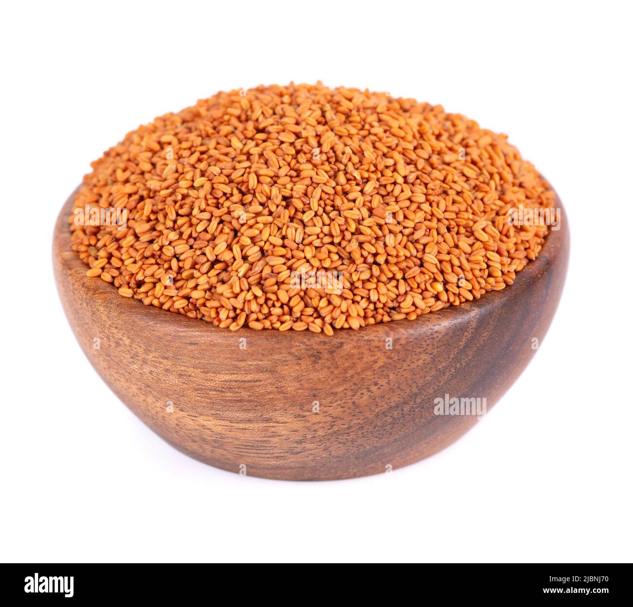 Camelina sativa seeds in wooden bowl, isolated on white background. Seeds of camelina or false flax. Raw material for camelina oil Stock Photo