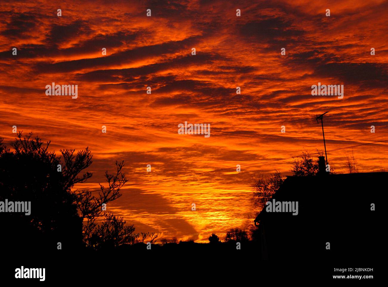 Magnificent sunrise with the sun shining on the underside of the clouds Stock Photo