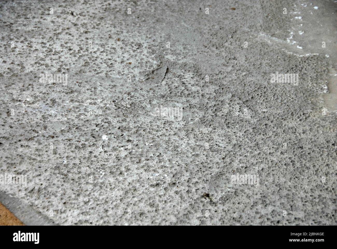 Freshly laid concrete on a building site with marks left by overnight rain Stock Photo