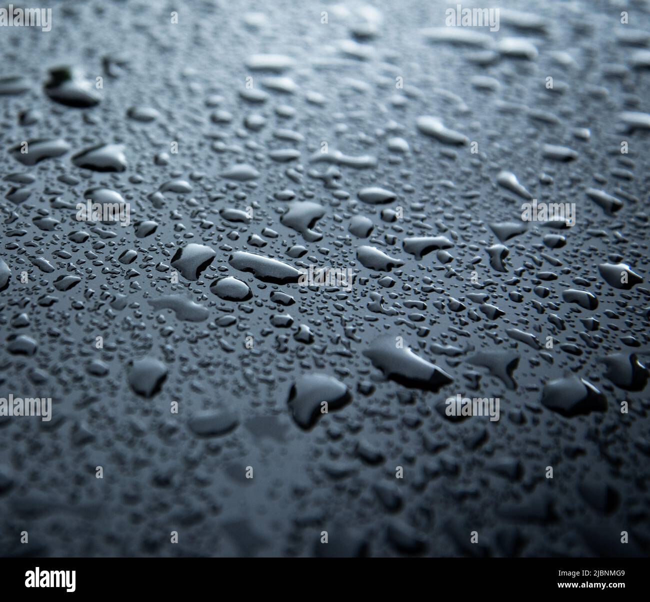 water spray droplets on black metallic surface Stock Photo