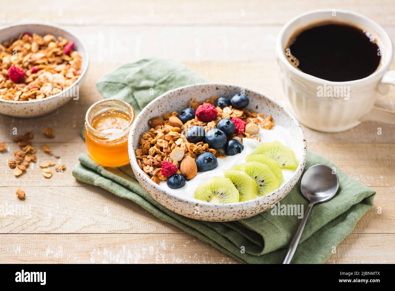 Granola bowl with greek yogurt, blueberries and kiwi on wooden table. Healthy breakfast food Stock Photo