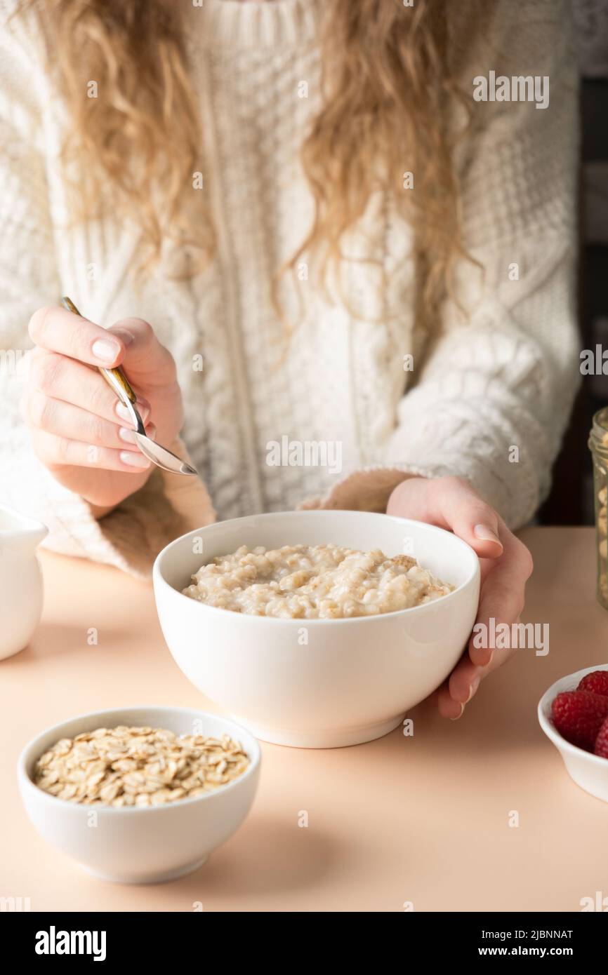 Oatmeal porridge bowl in female hands. Clean eating, dieting, vegetarian breakfast food for weight loss concept Stock Photo