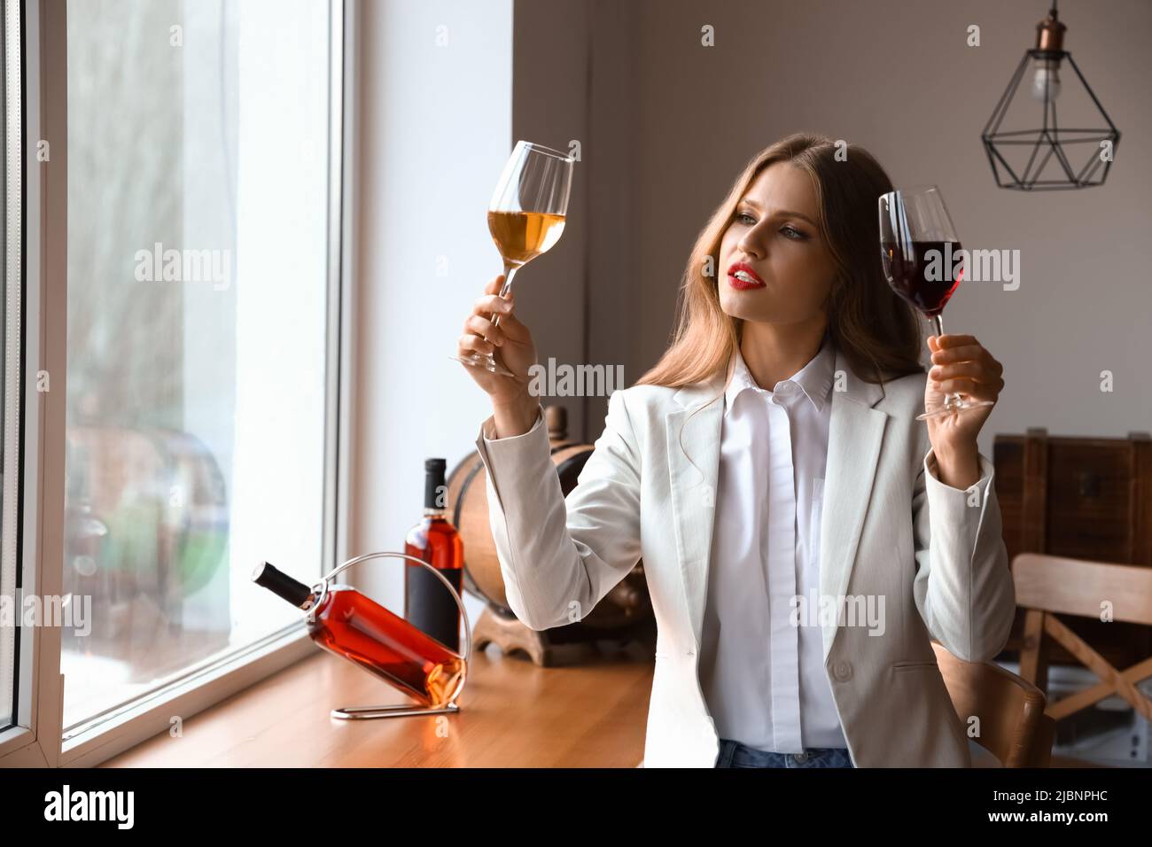 Beautiful young female sommelier tasting types of wine Stock Photo - Alamy