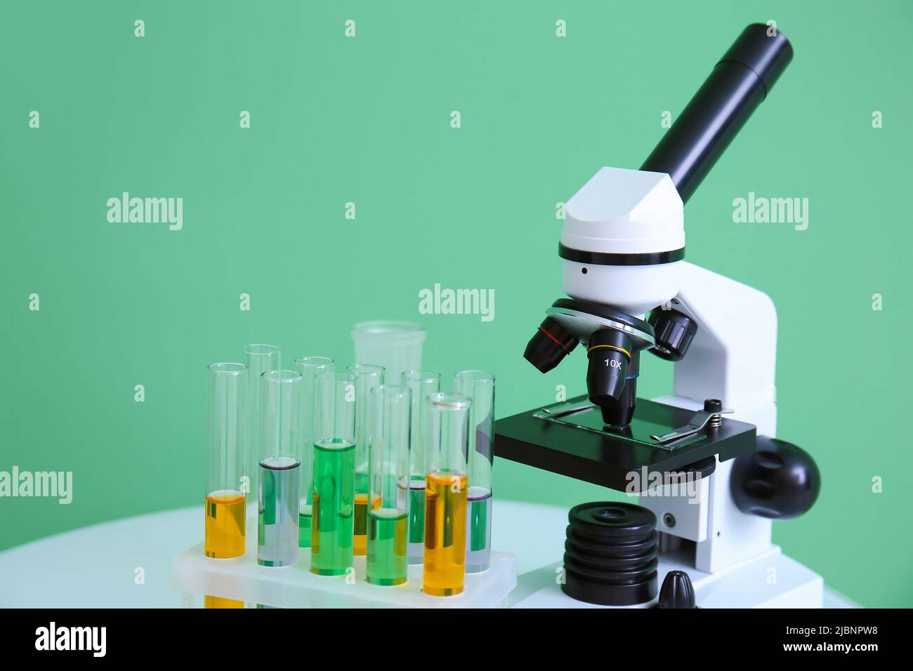 Modern microscope and test tubes with samples on green background Stock ...