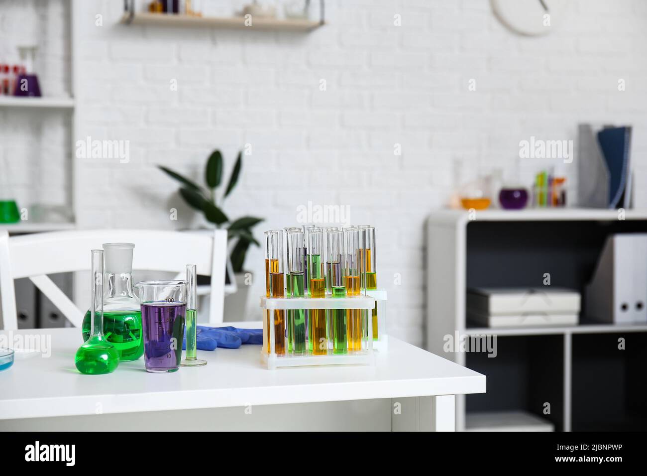 Different chemical glassware with samples on table in medical