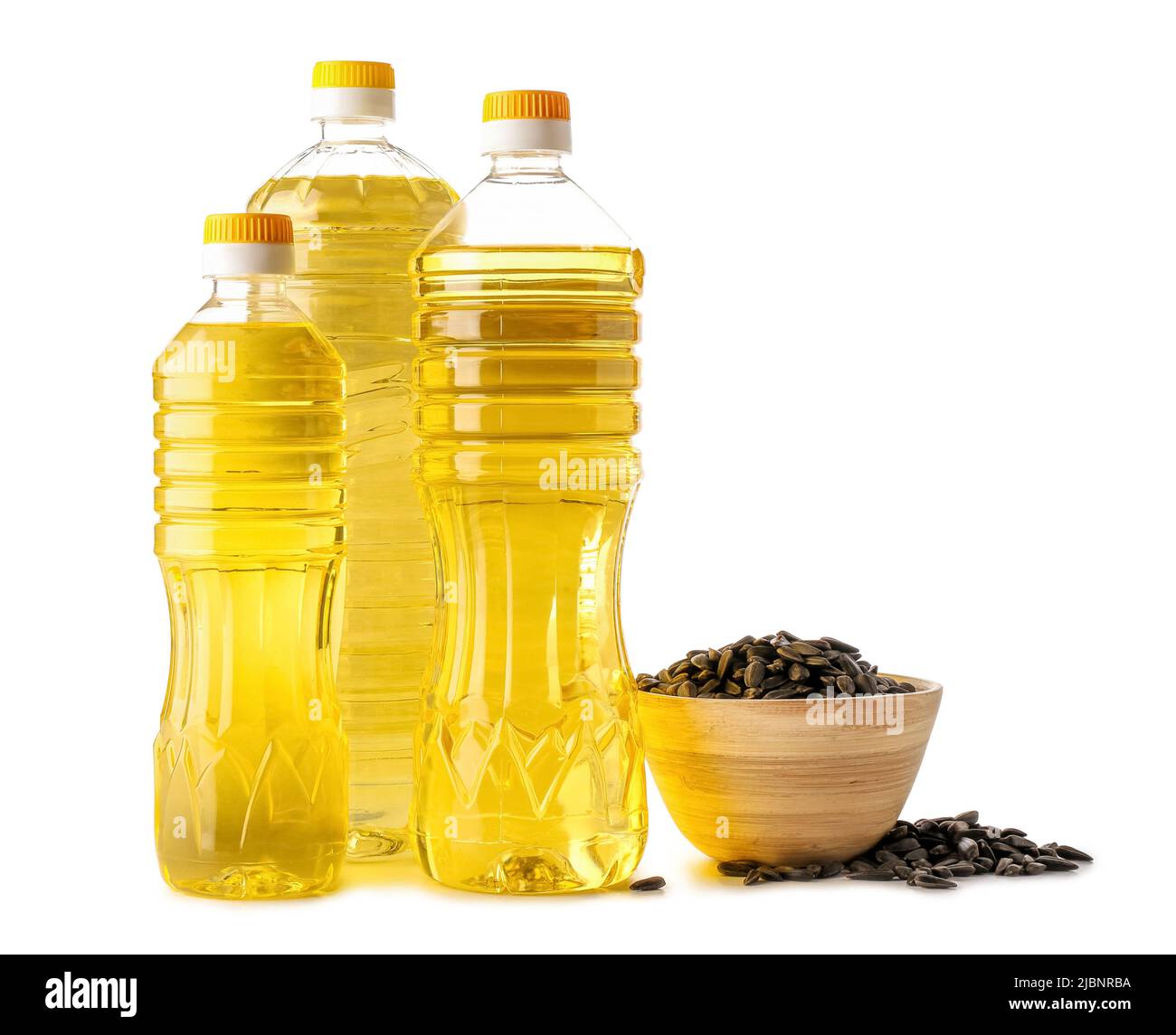 Different bottles of oil and bowl with sunflower seeds on white ...