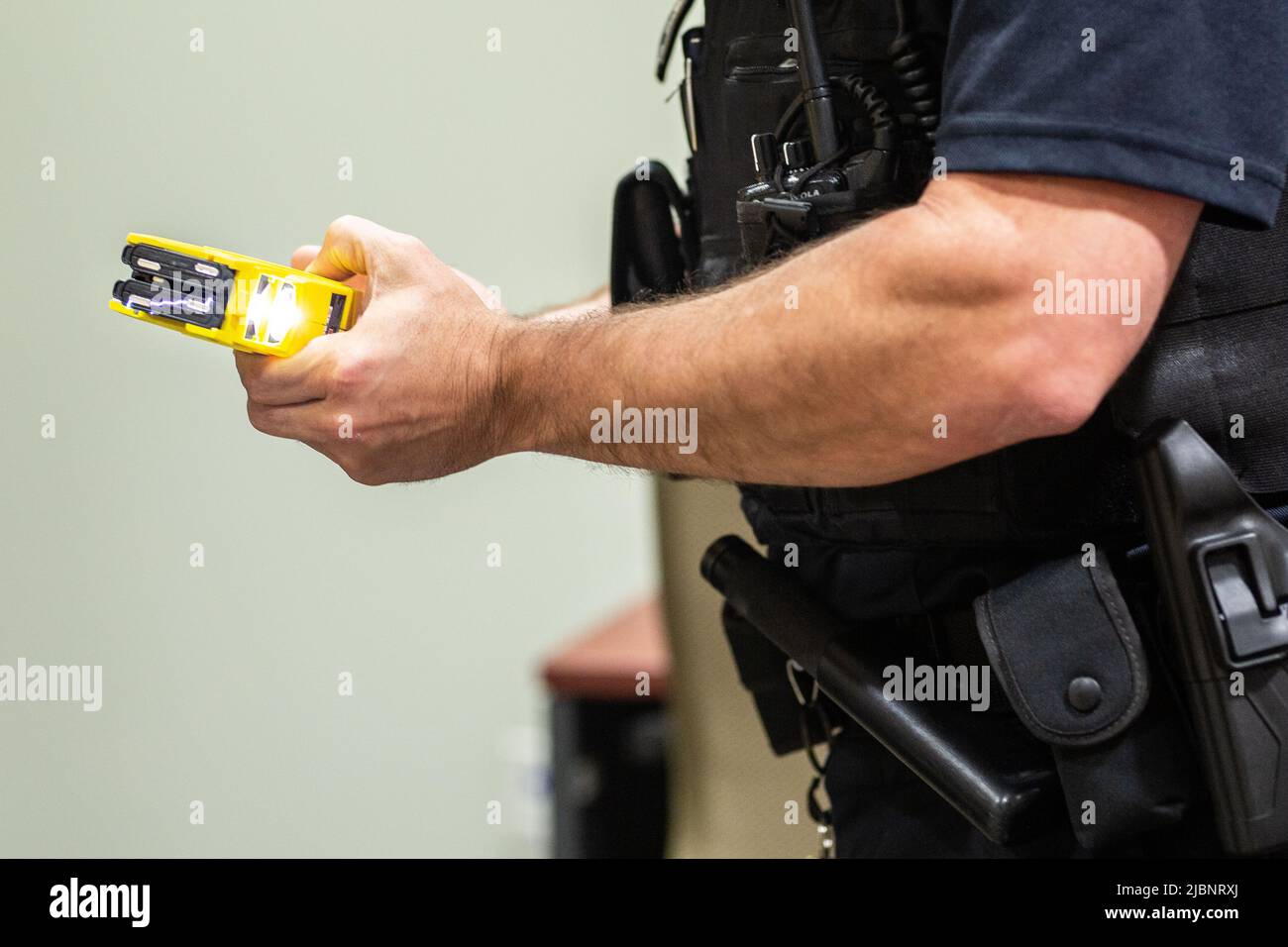 A taser gun in the hand of a police officer, Close up Stock Photo