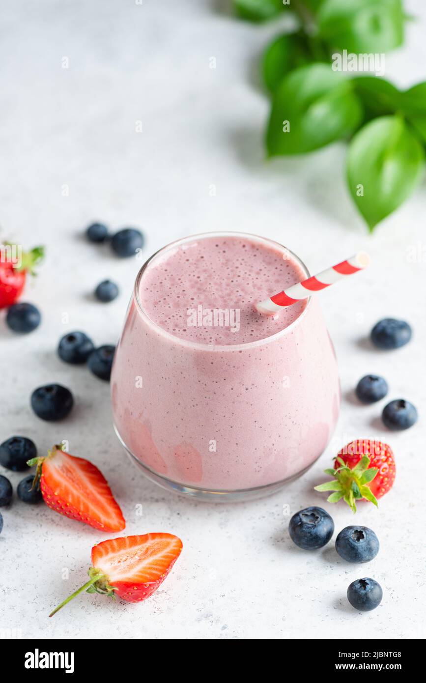 Berry fruit smoothie in glass on concrete background. Healthy food, refreshing summer smoothie or milkshake Stock Photo