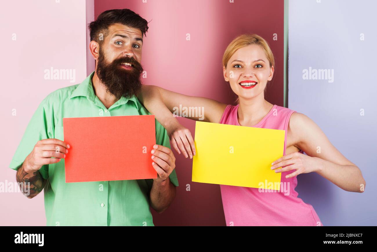 Smiling couple with empty advertising boards. Season Sale. Discount. Message board with copy space. Stock Photo